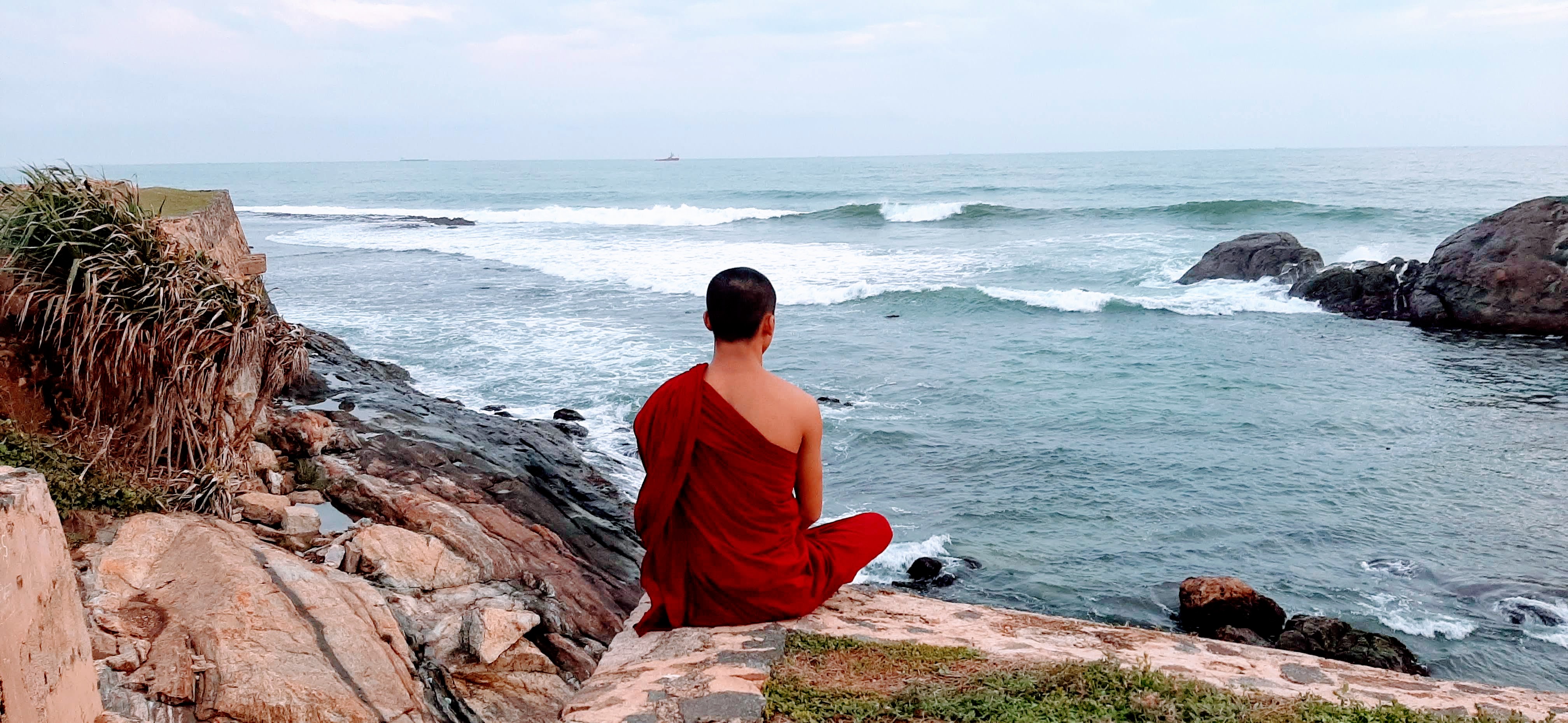monje meditando frente al mar en Galle